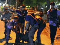 People help an unidentified injured person after a group of gunmen attacked a restaurant popular with foreigners in a diplomatic zone of the Bangladeshi capital Dhaka, Bangladesh, Friday, July 1, 2016. A group of gunmen attacked a restaurant popular with foreigners in a diplomatic zone of the Bangladeshi capital on Friday night, taking hostages and exchanging gunfire with security forces, according to a restaurant staff member and local media reports. (AP Photo)