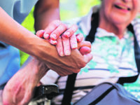 Nurse consoling senior woman holding her hand