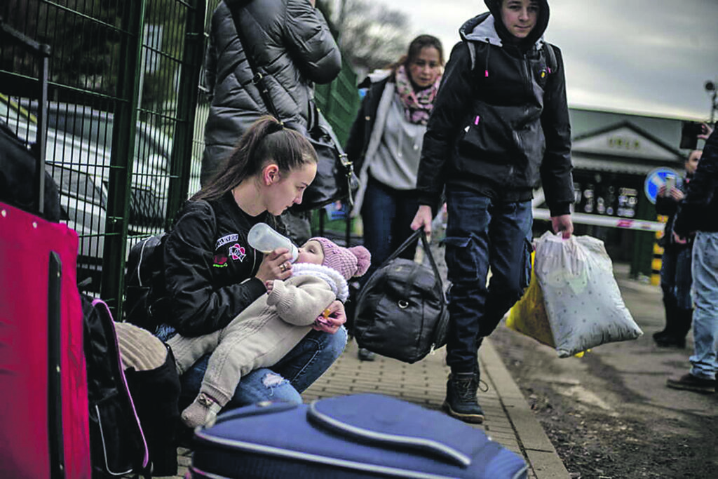 epaselect epa09783747 A woman feeds a child as people fleeing Ukraine arrive in Slovakia through the Ubla border crossing, 25 February 2022. Slovakia said it will let fleeing Ukrainians into the country following Russia's military operation in Ukraine. The Slovak Police Force announced on social media that people not holding a valid travel document will also be eligible for entry on an individual basis. EPA/MARTIN DIVISEK