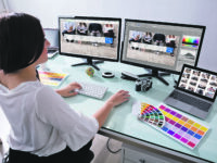 Close-up Of A Female Designer Working On Multiple Computer At Workplace